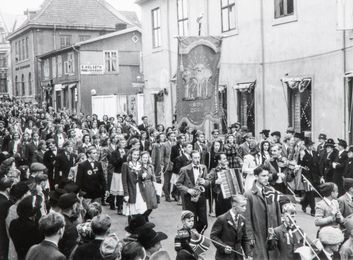 Bilder fra frigjøringsdagene i mai 1945. Borgertoget går ned Grønnegata i Hamar. Liers trio deltok i 17. mai toget. De spilte til vanlig på Astoria Hotel.