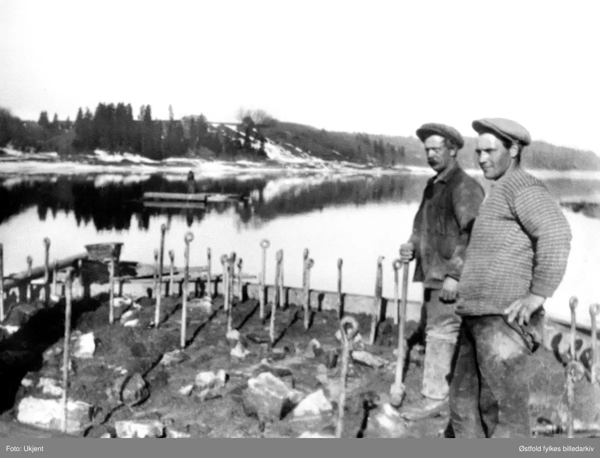 Nes lense i Skiptvet ca. 1920-30, under bygginga av de to betongtårnene nord for Nes (sør for Grønnsund). Tårnene står der enda. Funksjonen var å være ankerpunkt for beholdningslensa ("attholdslensa"). Her var strømmen sterk og det kunne samles mye tømmer. (Info fra Lars Sæther 2014)