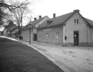 Utmed Ågatan i Linköping en mulen dag 1929. Miljön är i det närmaste oförändrad sedan fotografens dokumentation. Husens innehavare och dess verksamheter har naturligtvis skiftat. Från fasaden annonser den numera närmast bortglömda men vid tiden självklara firman Jubergs Hyrkuskverk, sedan bilismens intåg även med taxitrafik.