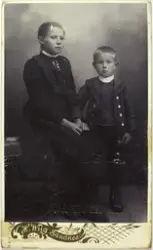 Atelierfoto av ei jente og ein gut, søsken. Anne Serigstad g