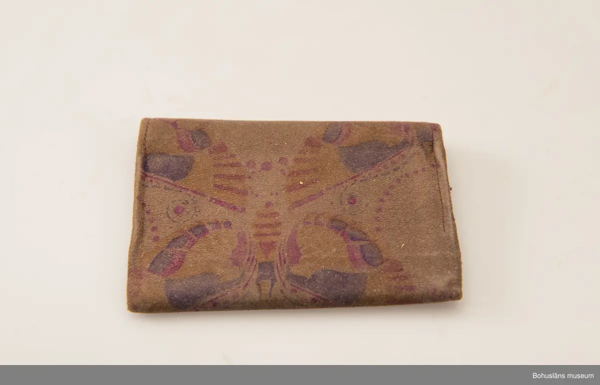 Brun börs av mockaskinn med tryckt blommönster i violett och rosa. Inuti blommönstrat foder på vit botten. Fyra fack.