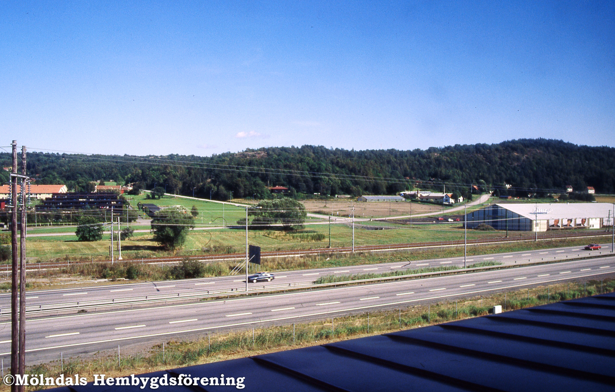 Sandbäck i Mölndal, september 1991. Vy över Kungsbackaleden mot tennishallen och gården Sandbäck 2.