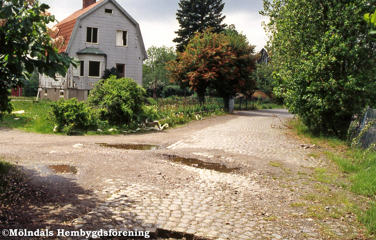 Bostadshus vid Skedebrogatan i Forsåker, Mölndal, i juni 1996. Husen på gatan rivs för att ge plats åt Åbromotet. Lägg märke till gatstenen.