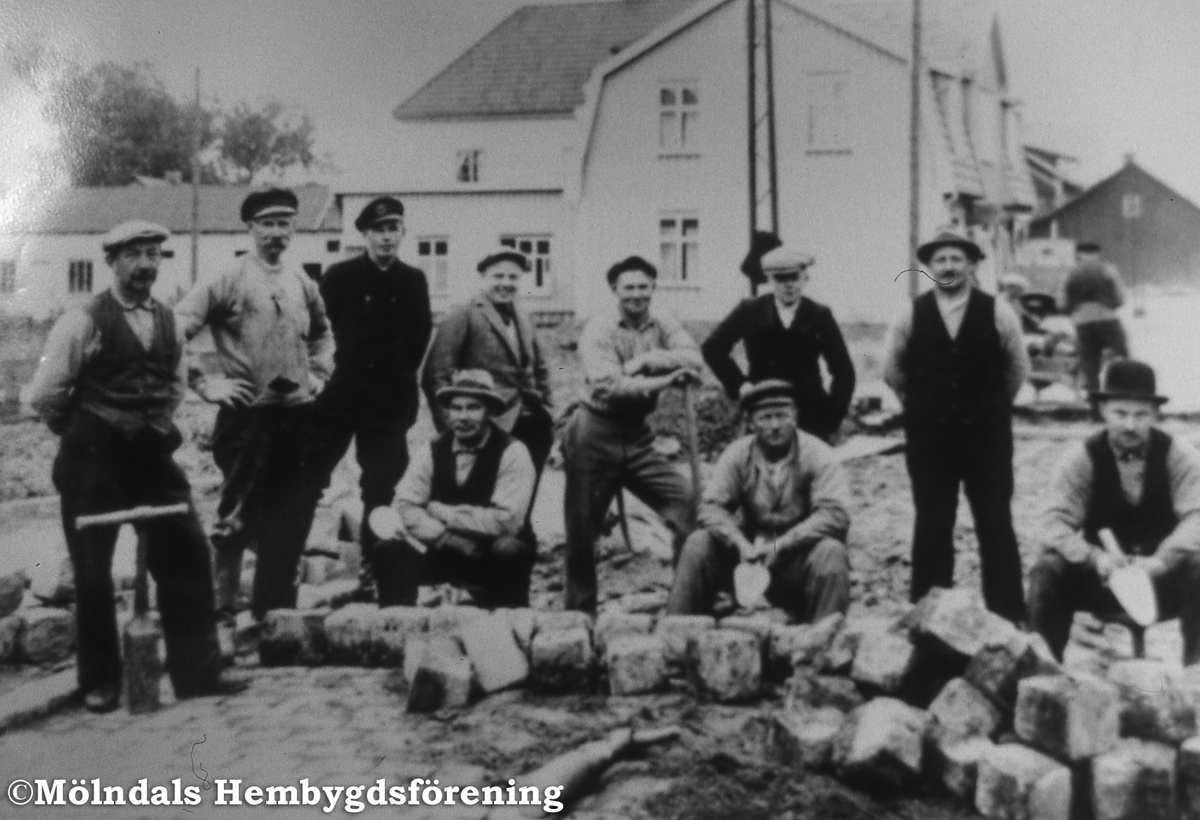 Stensättning av Göteborgsvägen vid Krokslätt i Mölndal på 1910-talet. I bakgrunden Kennedys hus. Namnen på stensättarna finns i diapärmen.

Orginalfoto: Malte Larsson