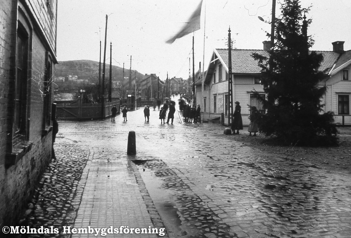 Mölndalsbro med bankhuset, Kungsbackavägen 1, en jul. Huset byggdes 1901 till speceriaffär. 1923 köpte Göteborgs och Bohusläns sparbank huset och öppnade bank. Källa: Inventering av Mölndalsbro. Fotografi taget på nyårsafton 1921.
