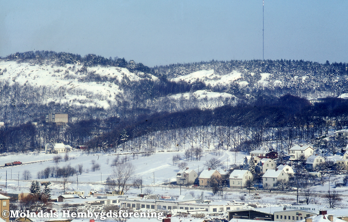 Vy mot bebyggelse i Lackarebäck och i Trädgården, Mölndal, vintern 1970. I förgrunden ses Kennedys cementvarufabrik.