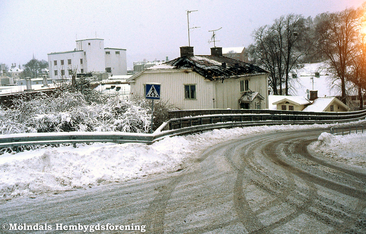 Ett hus inne på pappersbruket Papyrus fabriksområde har brunnit. En man brann inne. Efter något år revs huset. Vy från Norra Forsåkersgatan i Mölndal i januari 2002.