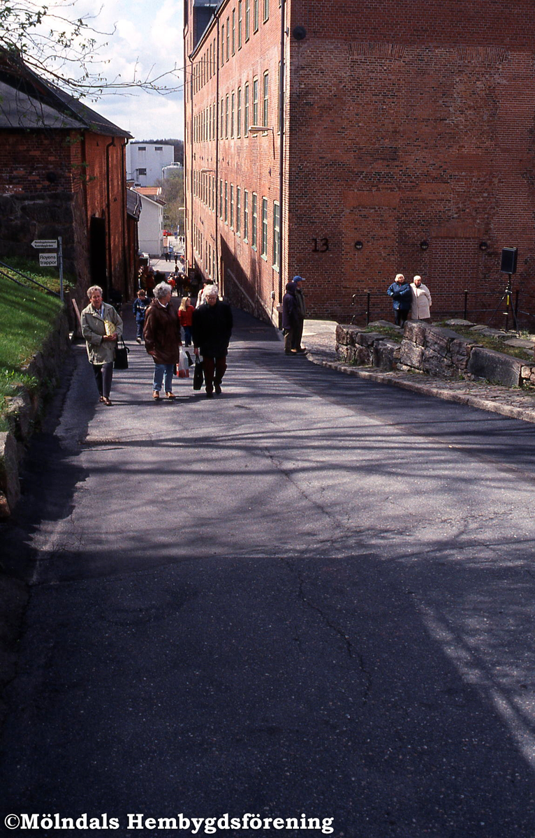 Gångtrafik på Götaforsliden i Mölndals Kvarnby under Kvarnbydagen den 28 april 2002. Till höger ses Stora Götafors med nr 13 och till vänster hembygdsmuseerna i nr 14.