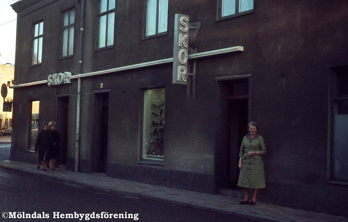 Tre kvinnor utanför Leon Rasmussons skoaffär på Kvarnbygatan 4 vid Gamla torget i Mölndal, 1970-tal. Kv 45:9.