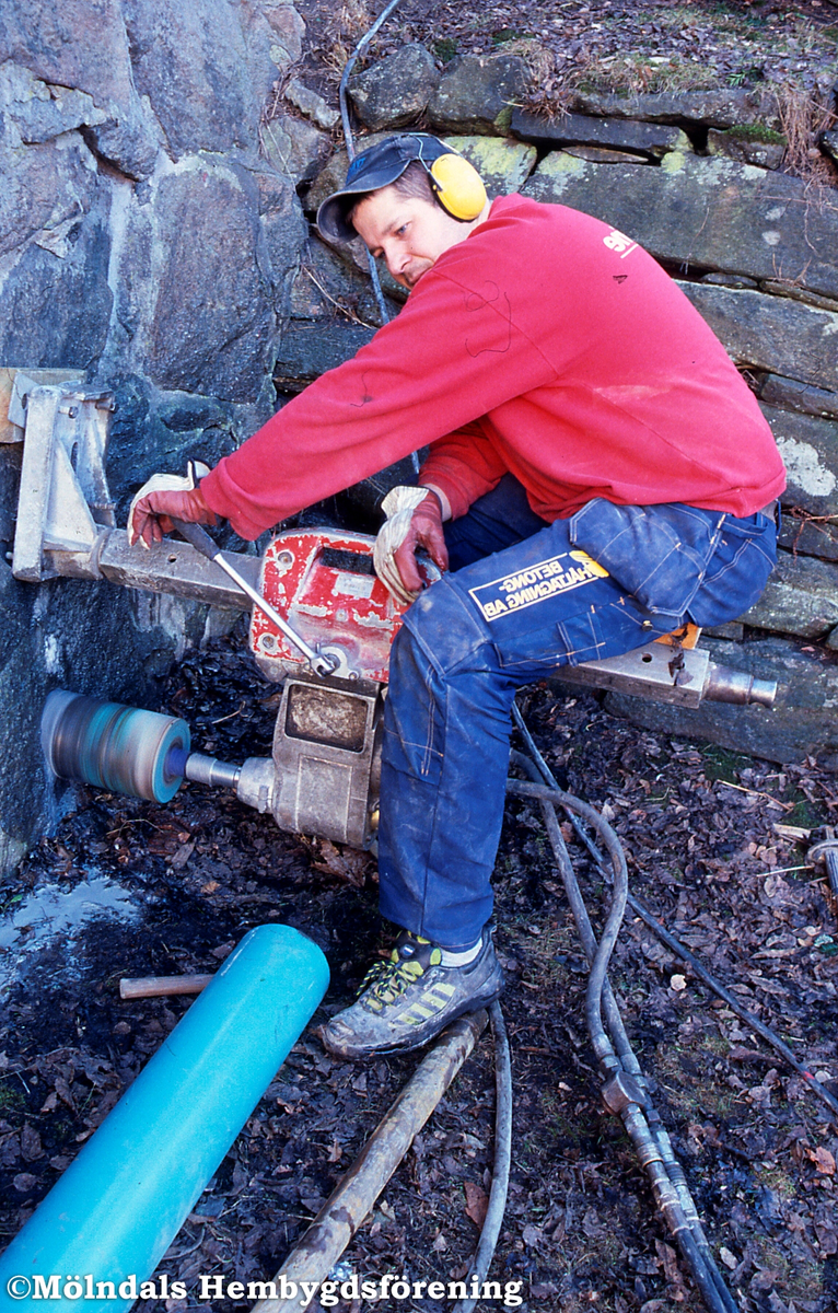 Götaforsliden i Mölndals Kvarnby den 14 mars 2003. En man borrar i muren till syratornet "Gomorra".