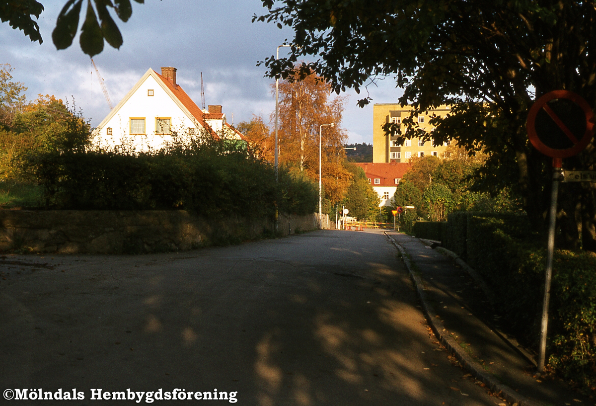 Lekskolegatan i Mölndal, år 1982. Stora Bosgårdens mangårdsbyggnad (Ungdomsgården) riven. Vy från Celsiusgatan. I bakgrunden ses byggnad tillhörande Mölndals sjukhus.