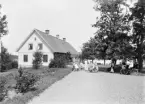 Man hade det till synes idylliskt i Sjöbacka den här dagen då fotograf Didrik von Essen kom på besök. Sannolikt var han väntad, möjligtvis beställd och med ett hastigt arrangemang skapades ett harmoniska ögonblick. Vi har inga besked om personerna på bilden men under perioden 1889 till 1903 arrenderades gården av familjen Tydén, varför dessa kan vara möjliga. Reservation dock för husfadern Christian August Tydén som gick bort 1897.