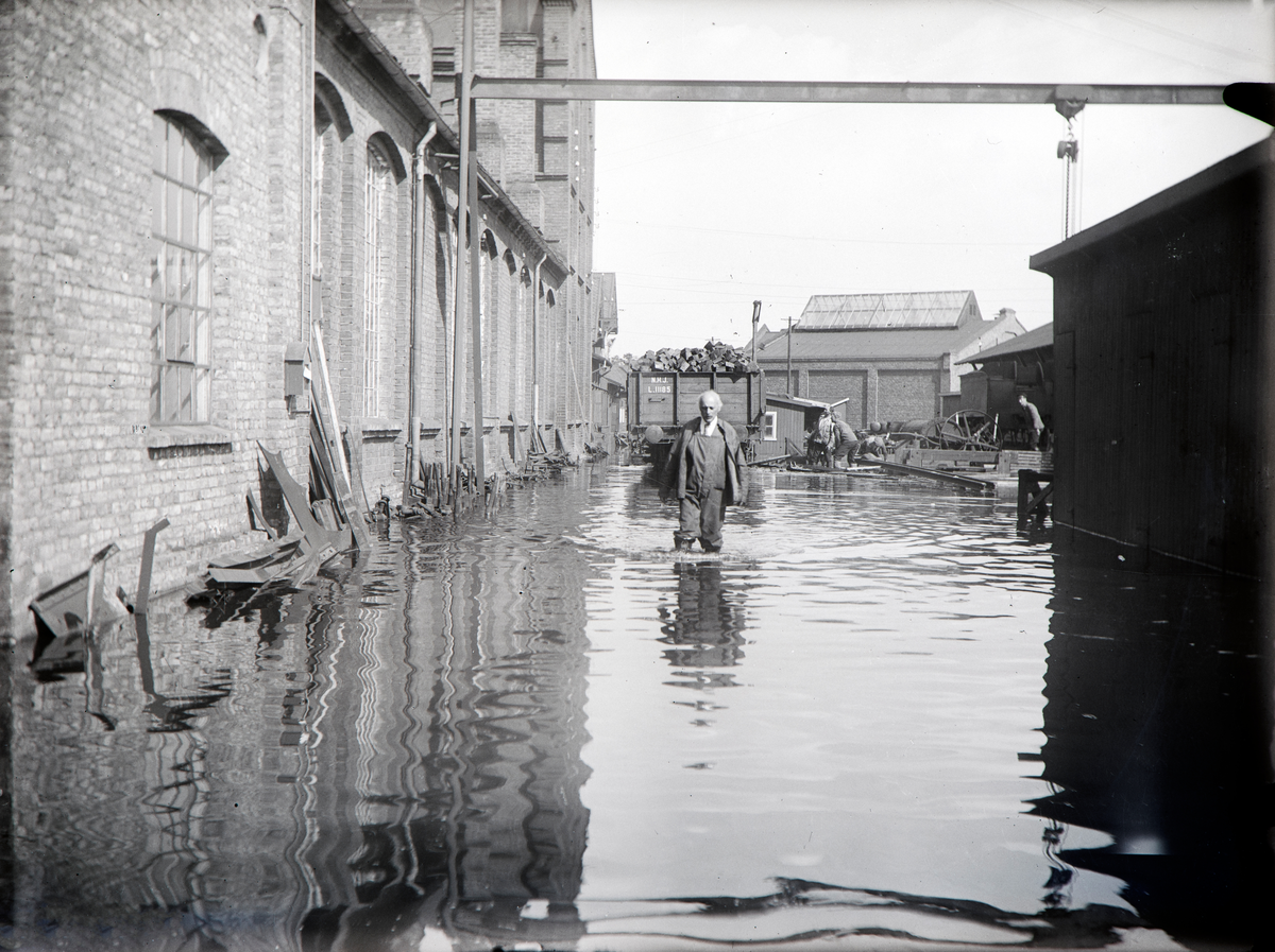 Hamar, Espern, Hamar Jernbaneverksted, Mjøsflommen 1927 på fabrikktomta, 6. juli vannstand 8,10 meter,  ingeniør John Landstad går med vadere i flomvannet,