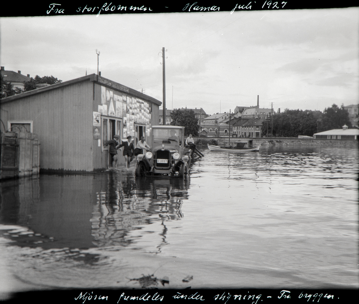 Hamar brygge, Mjøsflommen juli 1927, Chevrolet lastebil med registreringsnummer D-3057 tilhørende Hamar Dampskibsselkap foran ekspedisjonlokalet til Hamar Dampskibsselkap, barn leker i vannet,