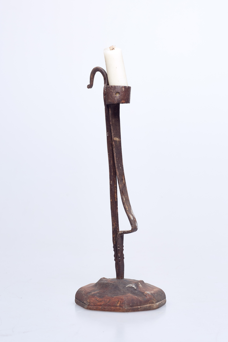 Foten av tre har syv kanter. Holderen er av jern og lyset står i en jernring.