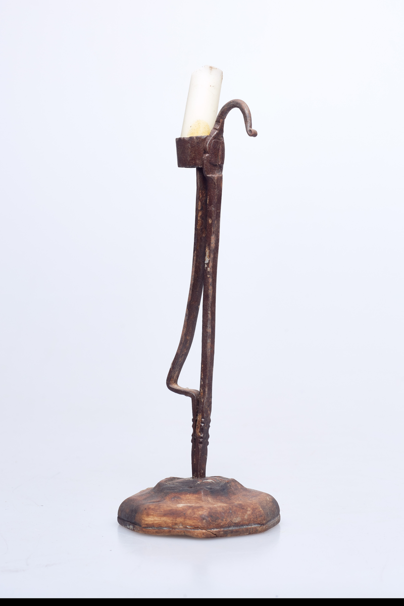 Foten av tre har syv kanter. Holderen er av jern og lyset står i en jernring.