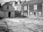 Gårdsinteriör från Nygatan 32 i Linköping 1930. I tid kort före rivningen av gårdens hus för ny markanvändning. Vy mot nordväst.