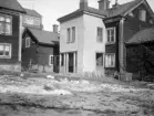 Fram till fotoåret 1930 kvarstod mamsell Dufvas gård i Linköping, med gatuhus mot korsningen Nygatan-Klostergatan. Här innergårdsmiljön med blicken riktad mot nämnda vägkors bortom gårdens byggnader. I bakgrunden skymtar bagare Linds fastighet som hjälp för orienteringen.