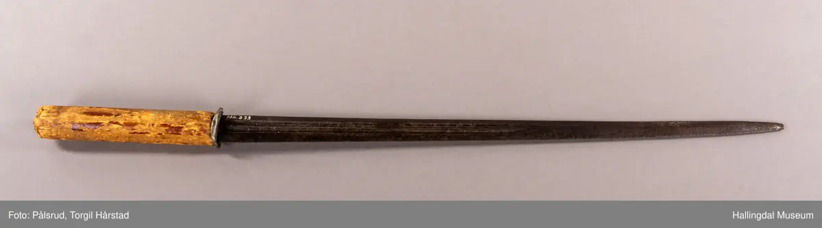 En stilett, eller dolk, fra Spania, fra 1600 tallet. Antatt omsmidd og senere påsatt et grovt håndtak i tre. 
Dette stilettbladet er antagelig laget av eller i verkstedet til Juan Martinez i Toledo, Spania. 