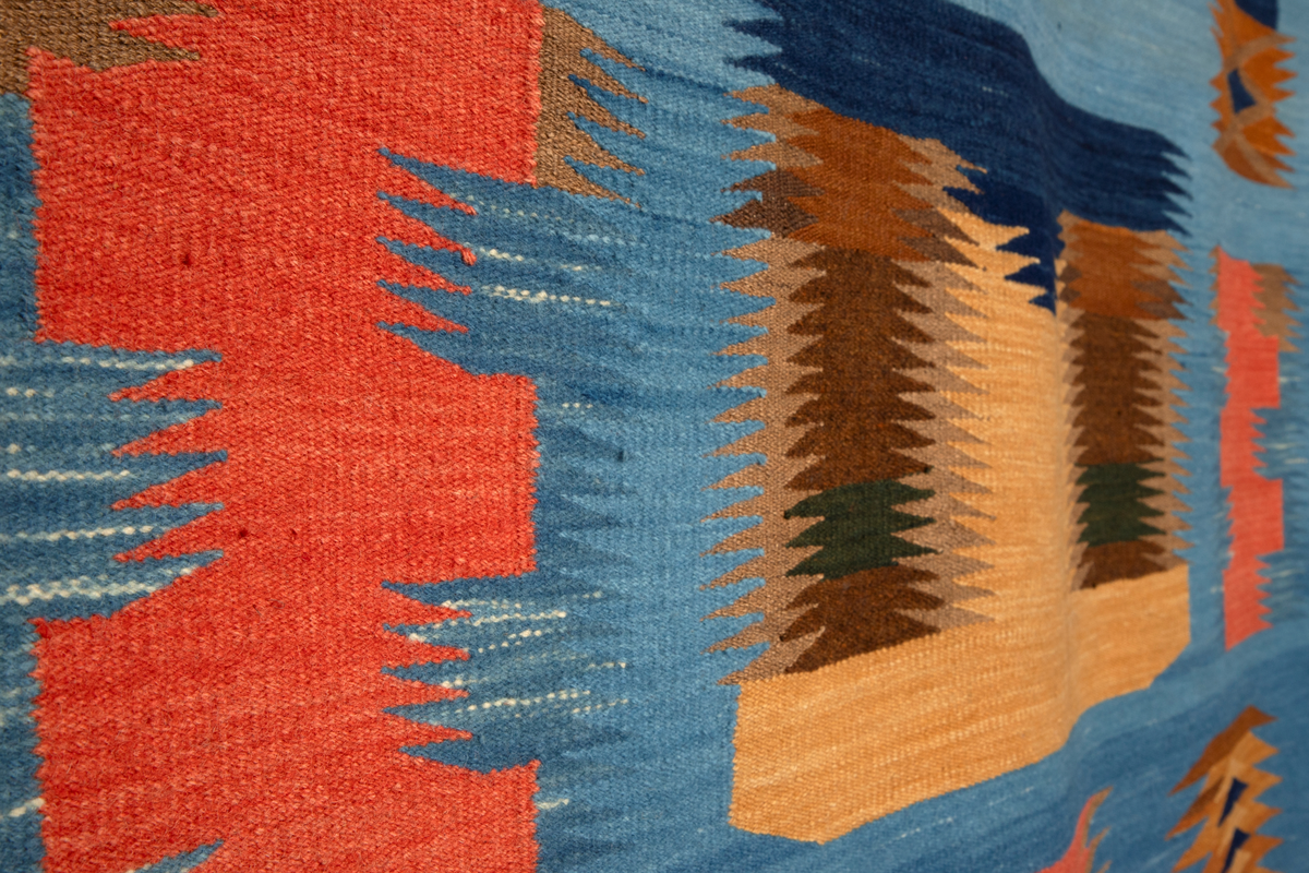 Ornamentalt, dekorativt, nonfigurativt motiv. Gule, oransje, brune og mørkeblå ornamenter på lyseblå bunn. Taggete formspill som optisk synes å "vibrere", kanskje som visuelt tordenskrall (jfr. tittelen). I et av de øvre feltene er verkets tittel og kunstnerens initialier vevd inn. En av de ornamentale formene i øvre del kan alternatitvt leses figurativt som et ansikt snudd på hodet.