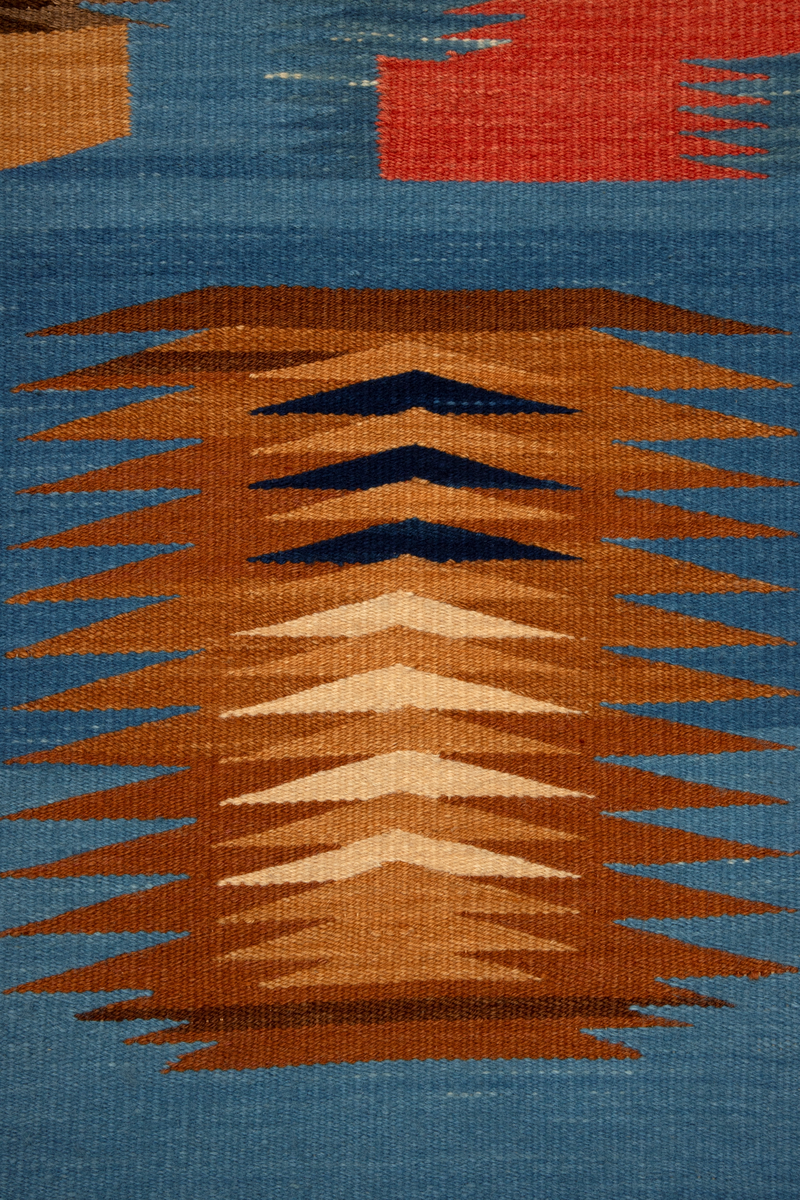 Ornamentalt, dekorativt, nonfigurativt motiv. Gule, oransje, brune og mørkeblå ornamenter på lyseblå bunn. Taggete formspill som optisk synes å "vibrere", kanskje som visuelt tordenskrall (jfr. tittelen). I et av de øvre feltene er verkets tittel og kunstnerens initialier vevd inn. En av de ornamentale formene i øvre del kan alternatitvt leses figurativt som et ansikt snudd på hodet.