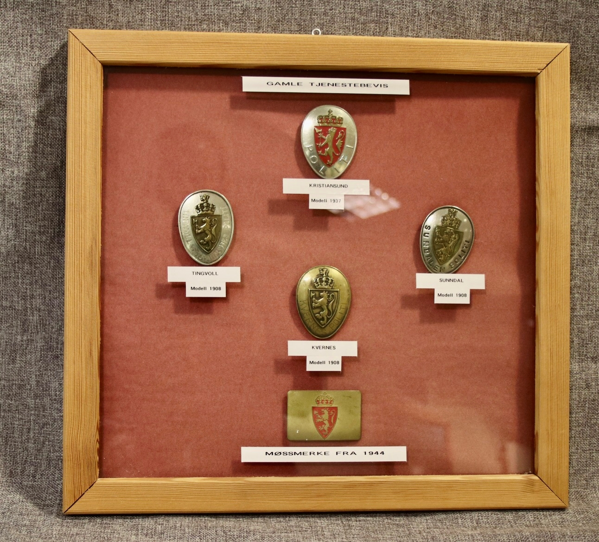 Fem polititegn montert i glass og ramme. 

Polititegn modell 1908 fra Tingvoll
Polititegn modell 1908 fra Kvernes
Polititegn modell 1908 fra Sunndal
Polititegn modell 1937 fra Kristiansund
Luemerke for polititroppene/svensketroppene modell 1944