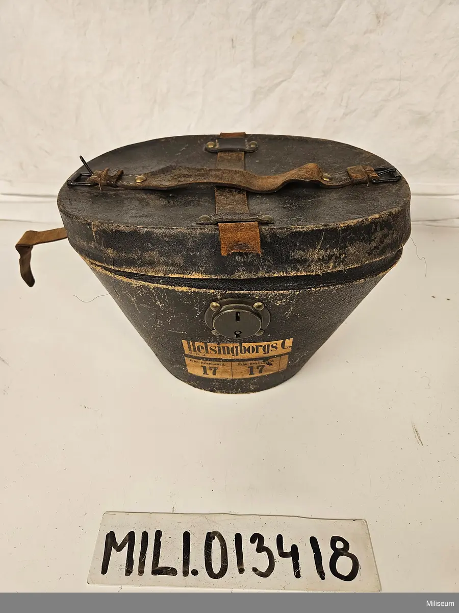 Käppi m/1880 styckjunkare vid A 6. Med tillhörande förvaringslåda, regnskydd och plym (pompong saknas).