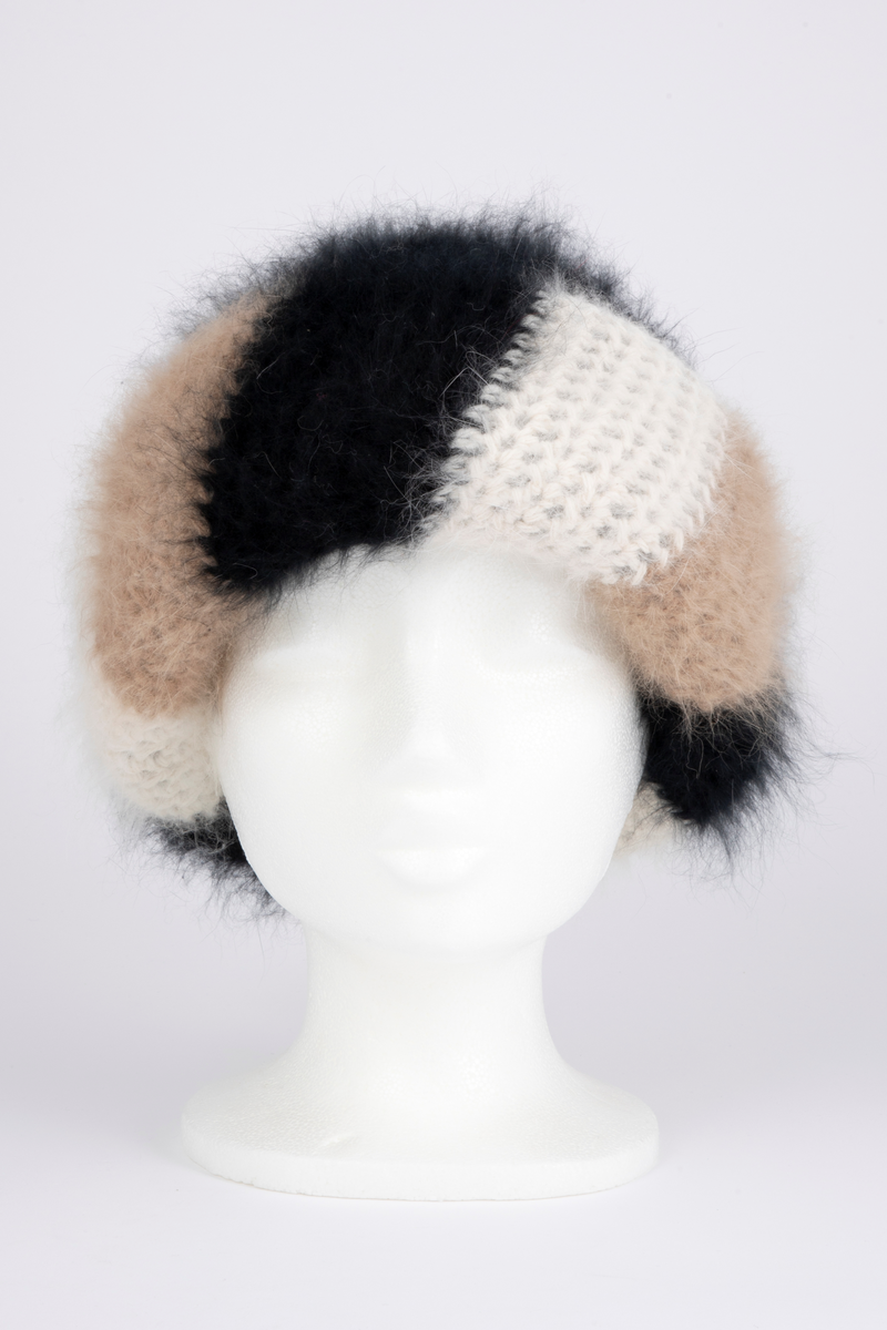 Heklet, muligens strikket, lue av angoraull. Tettsittende, med rund pull og bred oppbrett. Både pull og oppbrett er dobbel; pullen svart og oppbretten diagonalstripet, med brede striper i vekselvis sauehvitt, beige og svart. Lodden og myk angoraull utvendig, mens pullen innvendig er mindre lodden, og antagelig ikke angora. Oppbretten er først laget dobbel, deretter sydd på pullen og brettet opp, slik at den danner 4 lag og blir stor og fyldig. Pullens to lag er ikke festet i hverandre unntatt nederst, der den har en isydd hattestrikk for å holde spensten.