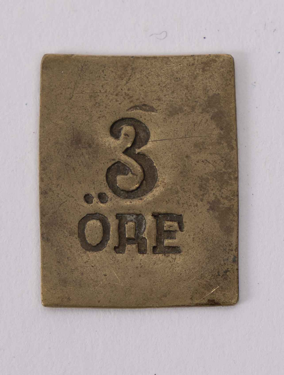 Betalingsmynter fra Laxevaags Dampfærgeselskab. Pollett med verdi 3-øre.  Del av gruppering med tilsammen 360 stk. polletter i messing med rektangulær form preget med tekst "3 øre". Ligger i enkel trekasse hvor deler av topp-plate mangler.