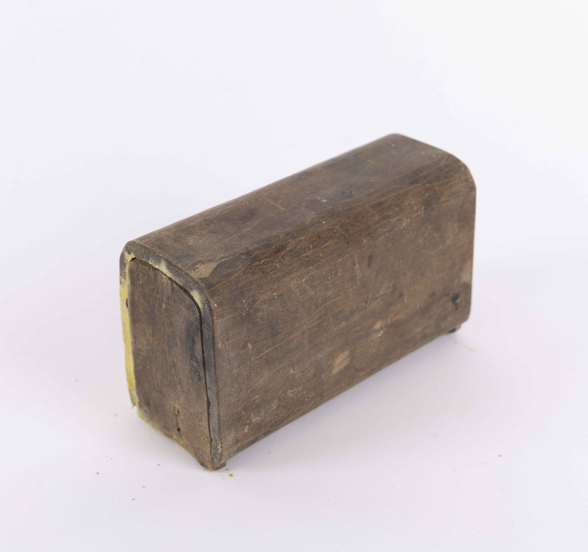 Rektangulær treeske med lokk i topp og bunn. Esken har buede hjørner og flate lokk. Lokkene kan skyves inn og ut i spor.