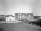 Vy mot Linnéskolan i Linköping. Fotografi från 1903 eller kort därefter. Skolan var vid tiden nyligen invigd och inrymde närmare 30 klassrum vid sidan av slöjdsalar och skolkök. Byggd före stadens elektrifiering var standarden emellertid enkel, vilket även gällde de sanitära utrymmena. Den lilla kvadratiska byggnaden hitom skolan utgjorde ett av skolans två avträden. Efter en eldsvåda 1923 fick skolan ett enklare uttryck. Det vita huset till vänster bar adressen Klostergatan 68 och hade stått inflyttningsklart 1903.