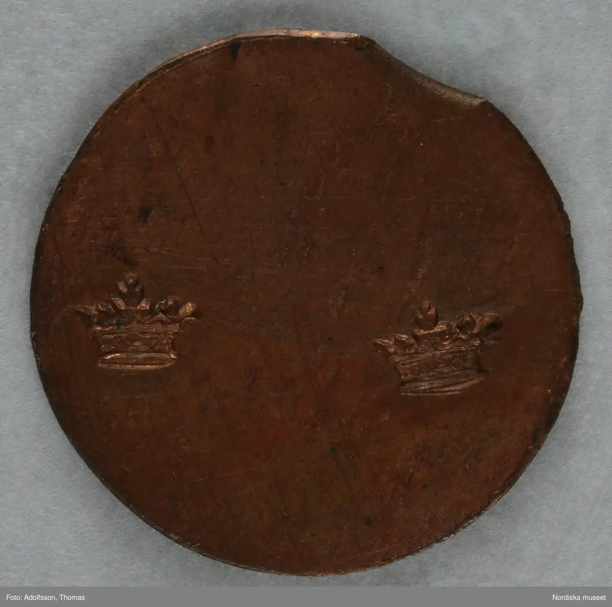 Pollett av koppar, rund, inpräglat 2 kronor.
