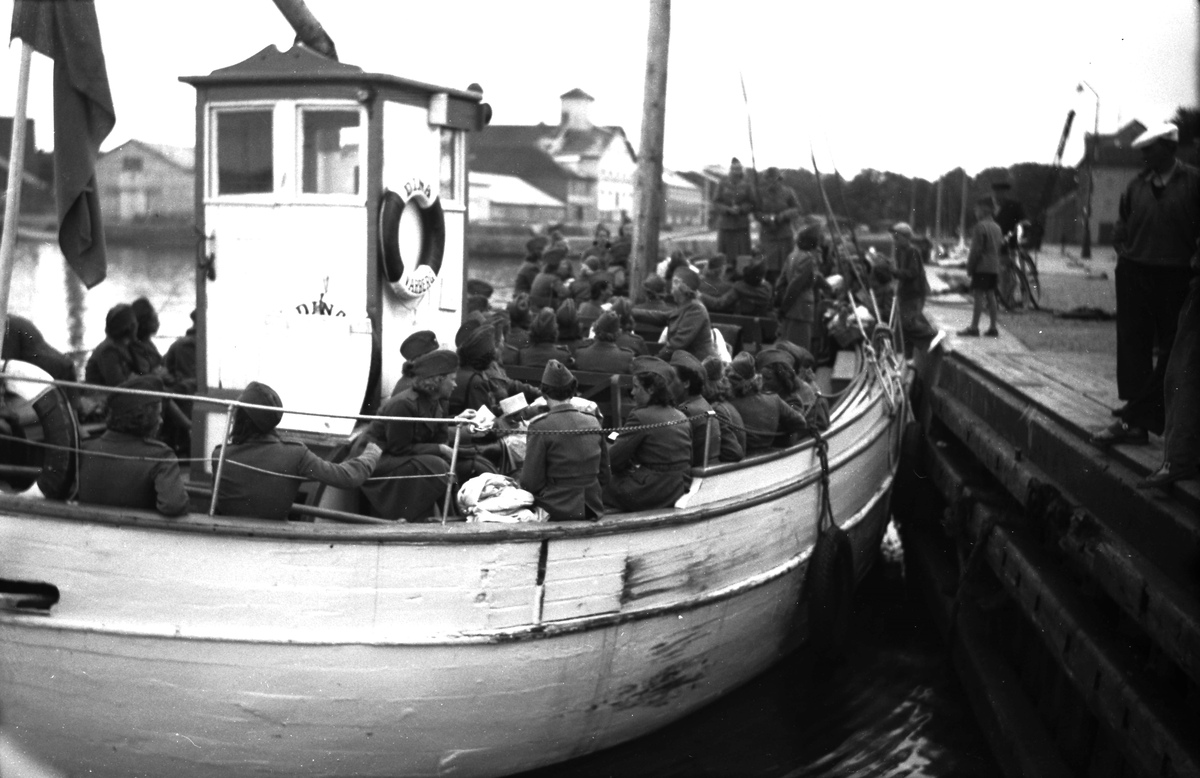 Getteröbåten Diana (Dina?) fullastad med lottor släp lämnar Varbergs hamn. I bakgrunden syns hamnmagasinen. Troligen i samband med andra världskriget.