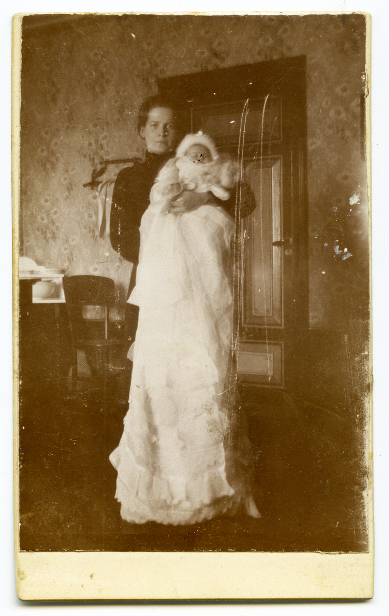 Karin Anderson med barn i dåpskjole (Selma?) 1903.
Bilde er fra fotoalbum GM.036888.