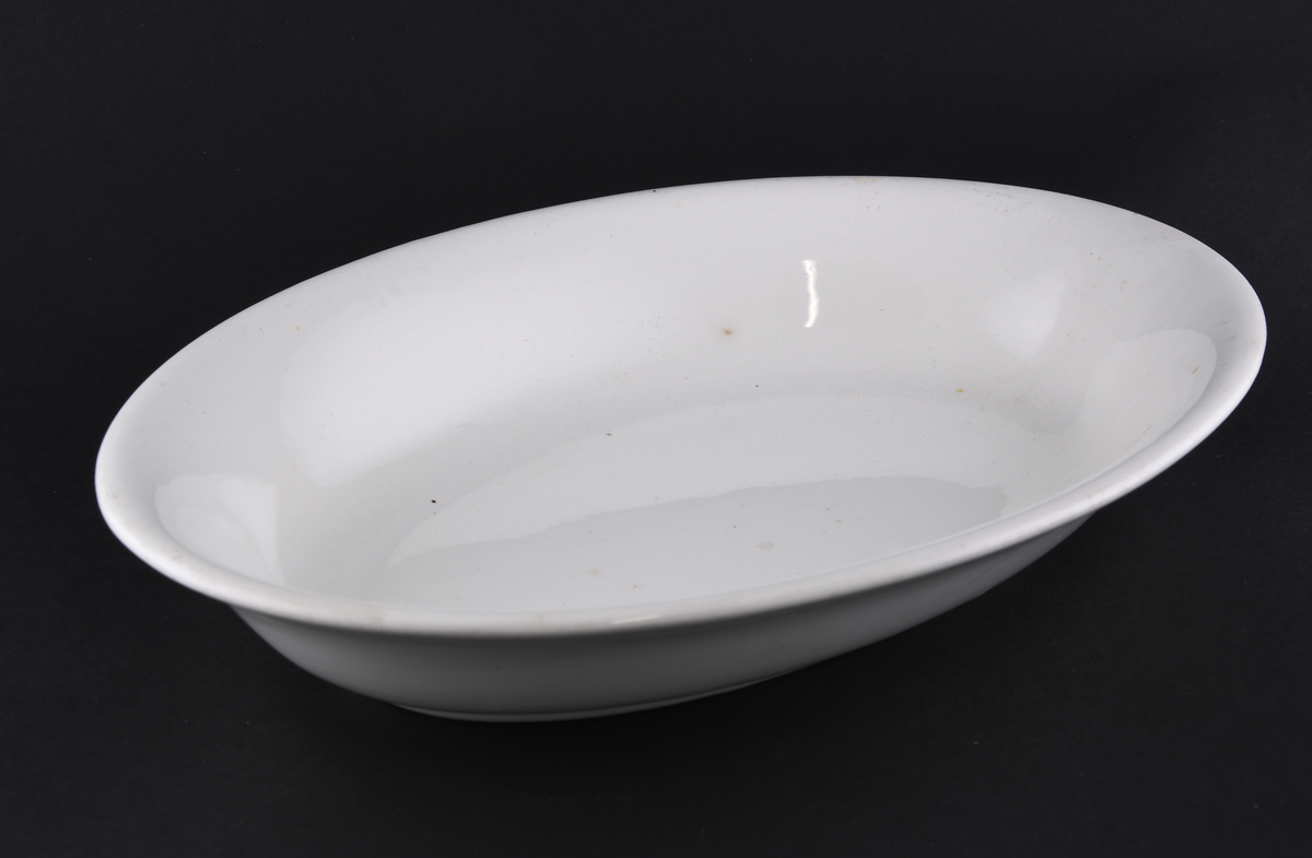Hvitt ovalt serveringsfat laget i steintøy.