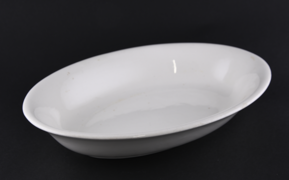 Hvitt ovalt serveringsfat laget i steintøy.