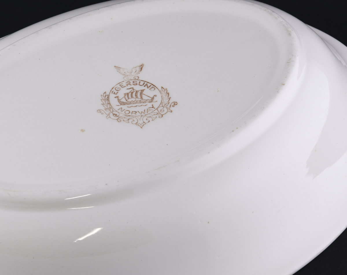 Hvitt ovalt serveringsfat laget i steintøy.