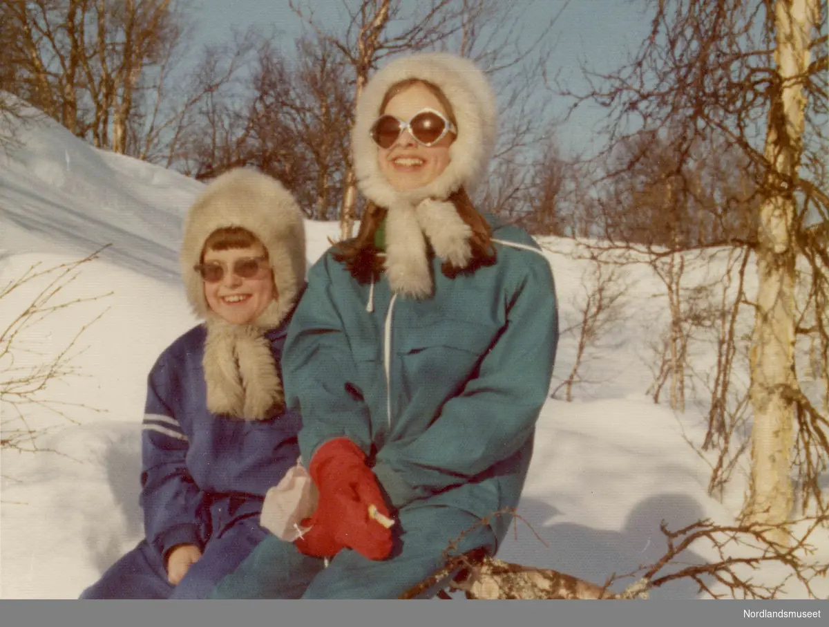 To barn sitter ute. Det er vinter. De har på seg vinterklær. Øyunn og Ingvild.