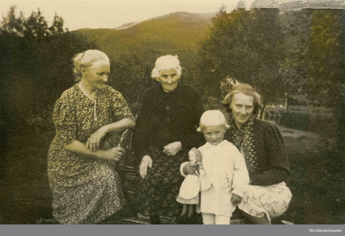 Tre kvinner og et barn, fotografert utendørs. Barnet holder en dukke. Skog og fjell i bakgrunnen. Til venstre Annie Djupos, Kristine, Turid og Valborg (datter av Annie).