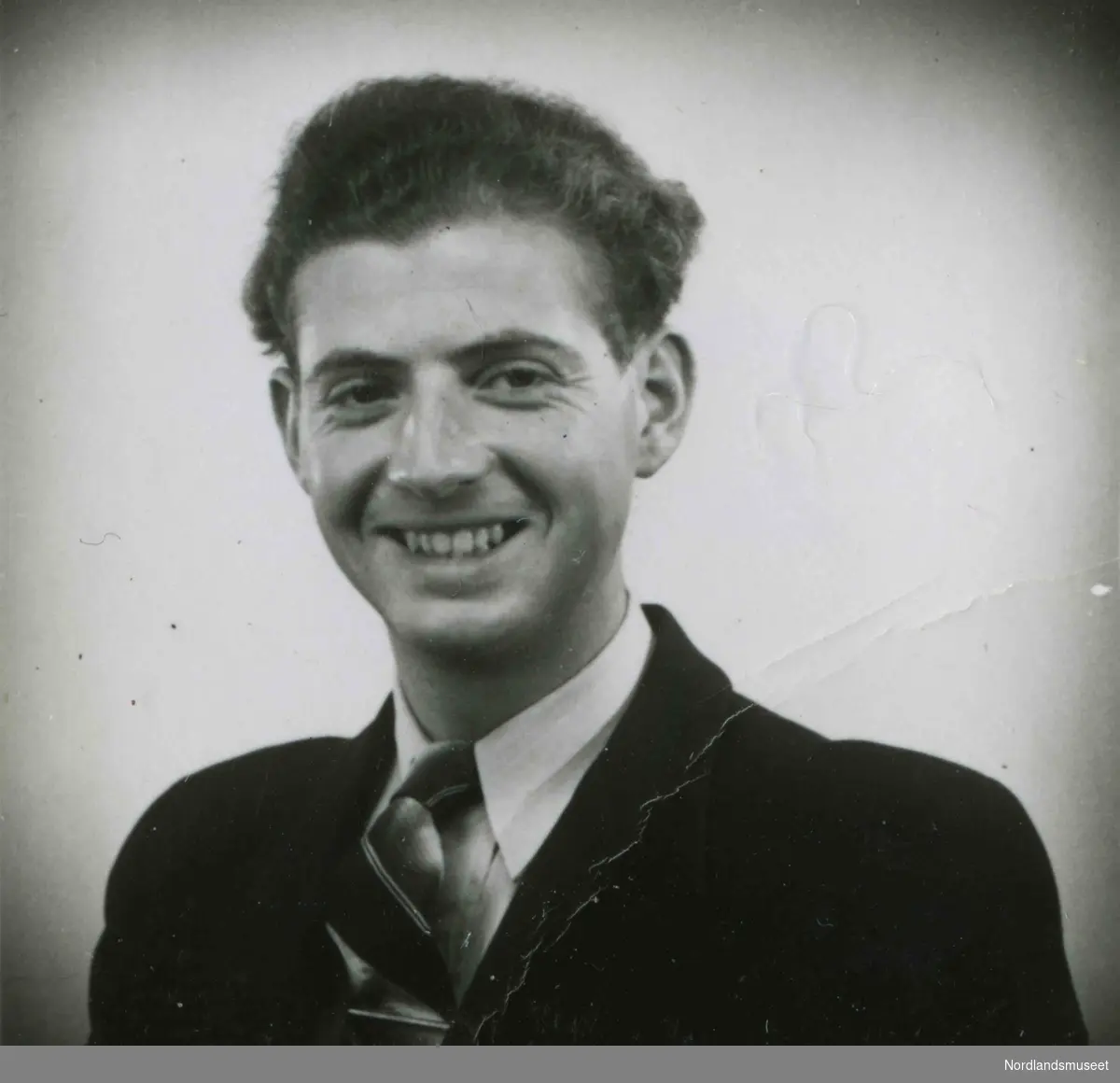 Brystbilde av ung mann med dress og slips. Bildetekst: "Arthur Moss 1942".