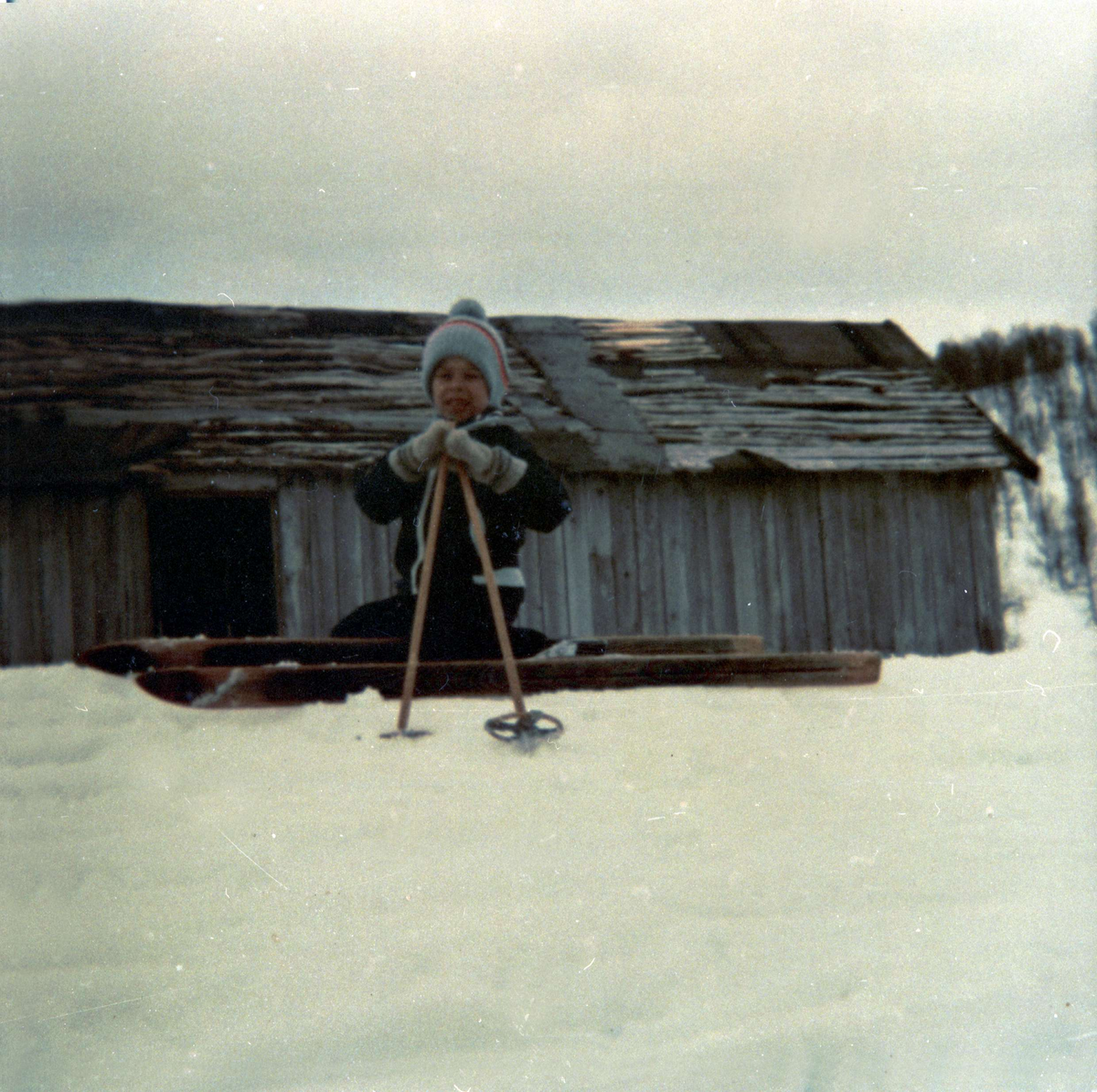 Gutt på ski foran løe på Blåfjell.