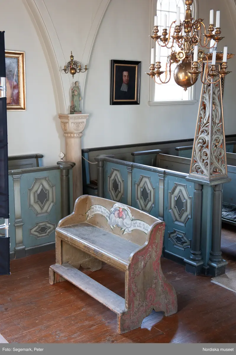 Brudstol (vigselstol) med plats för två i Julita kyrka, Södermanland. På ryggens framsida det brinnande hjärtat, en kärlekssymbol och text på tyska, latin och svenska.. Brudstolen har troligen ursprungligen stått i Arbrå kyrka, Hälsingland. Datering 1770-1780-tal.