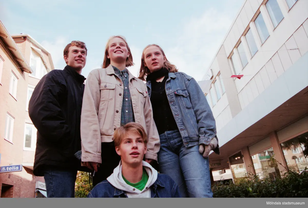 Fyra ungdomar på Brogatan. Mölndalsbro i dag - ett skolpedagogiskt dokumentationsprojekt på Mölndals museum under oktober 1996. 1996_1005-1023 är gjorda av högstadieelever från Kvarnbyskolan 9A, grupp 6. Se även 1996_0913-0940, gruppbilder på klasserna 1996_1382-1405 samt bilder från den färdiga utställningen 1996_1358-1381.