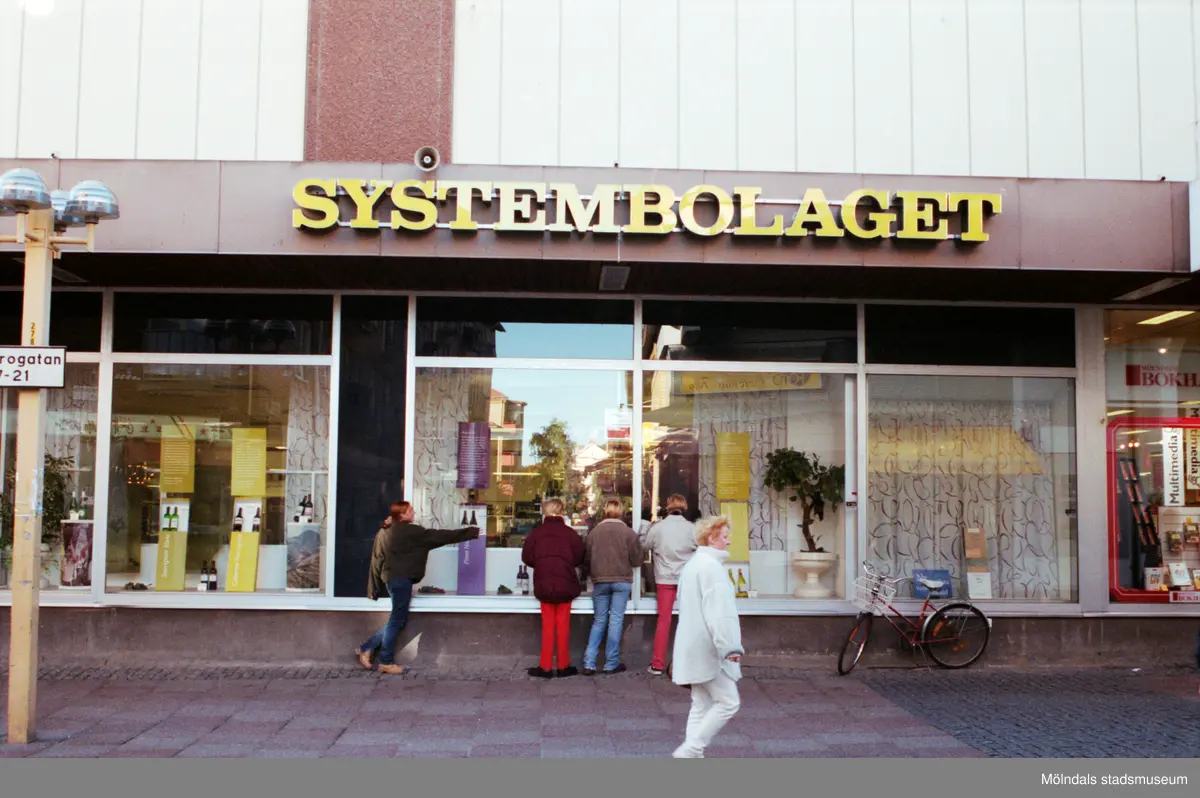 Systembolaget på Brogatan. Mölndalsbro i dag - ett skolpedagogiskt dokumentationsprojekt på Mölndals museum under oktober 1996. 1996_1042-1051 är gjorda av högstadieelever från Kvarnbyskolan 9C, grupp 2. Se även 1996_0913-0940, gruppbilder på klasserna 1996_1382-1405 samt bilder från den färdiga utställningen 1996_1358-1381.