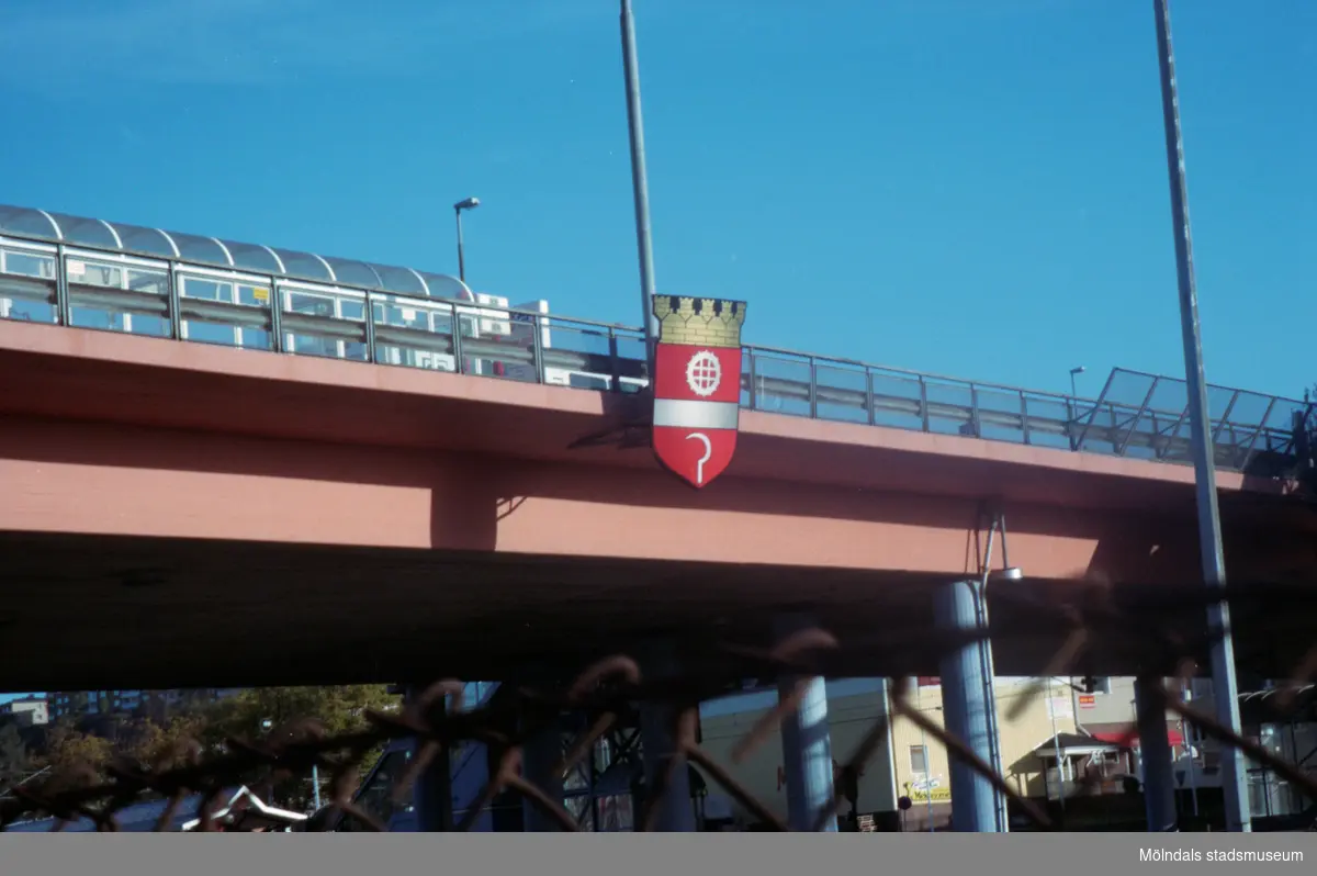 Stadsvapnet/kommunvapnet uppsatt på bron. Mölndalsbro i dag - ett skolpedagogiskt dokumentationsprojekt på Mölndals museum under oktober 1996. 1996_1079-1097 är gjorda av högstadieelever från Kvarnbyskolan 9C, grupp 4. Se även 1996_0913-0940, gruppbilder på klasserna 1996_1382-1405 samt bilder från den färdiga utställningen 1996_1358-1381.