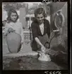 568 F. Stieg Trenter, Torremolinos. Två flickor hämtar vatten vid en springbrunn på ett torg.