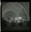 1950. Leksands kyrka. Folk stående i kyrkbänkar