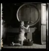 1950. Frankrike. Flicka tappar ut vin från en tunna.