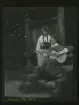 Porträtt av två kvinnor i folkdräkt, den ena med gitarr. Skansen, Stockholm.