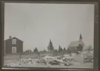 Fotografens anteckning: Fru Markströms gård med kyrkan i bakgrunden.